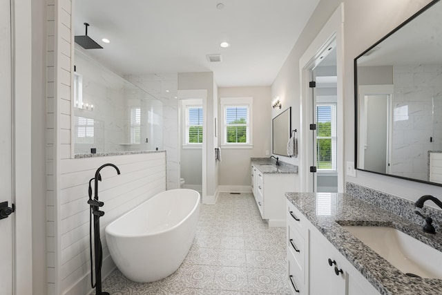 bathroom featuring vanity and independent shower and bath