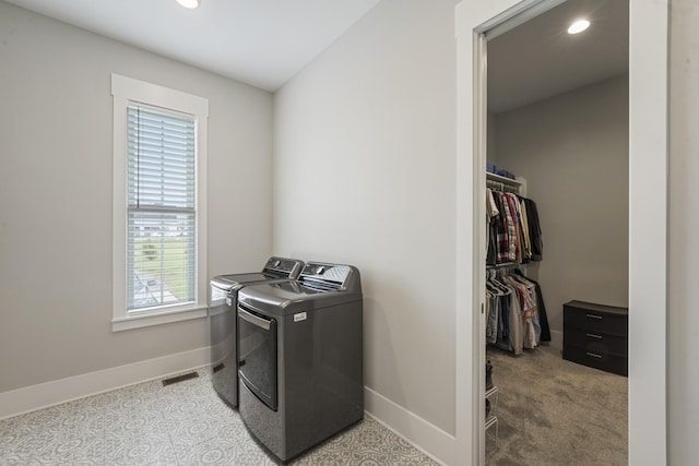 laundry room featuring washing machine and clothes dryer and light carpet