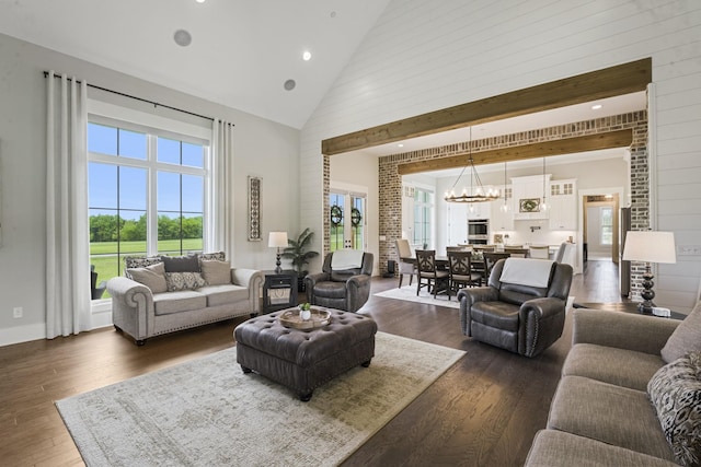 living room featuring dark wood-type flooring, a chandelier, and high vaulted ceiling