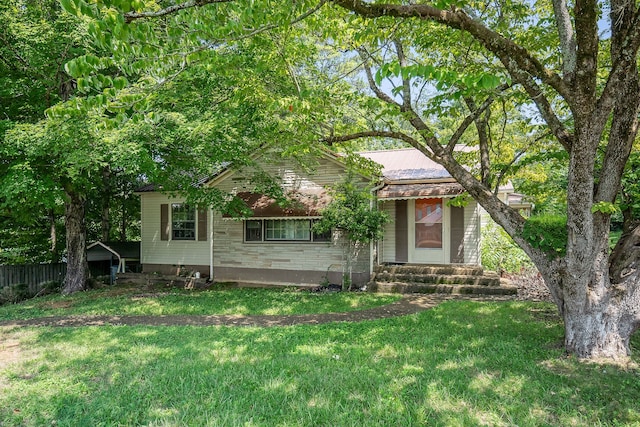 view of property hidden behind natural elements with a front lawn