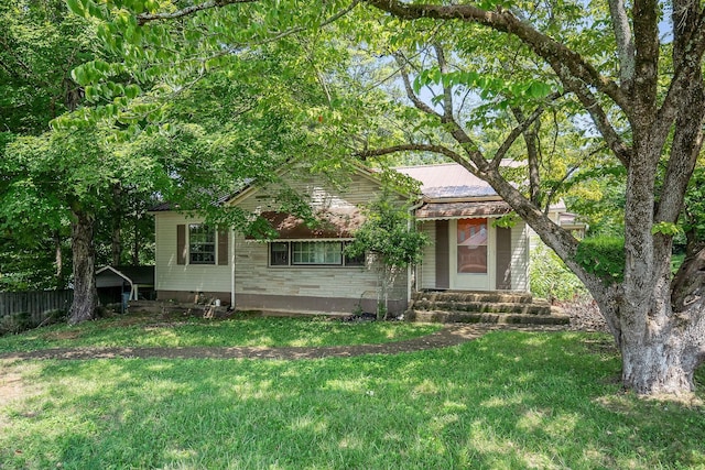 view of property hidden behind natural elements featuring a front yard