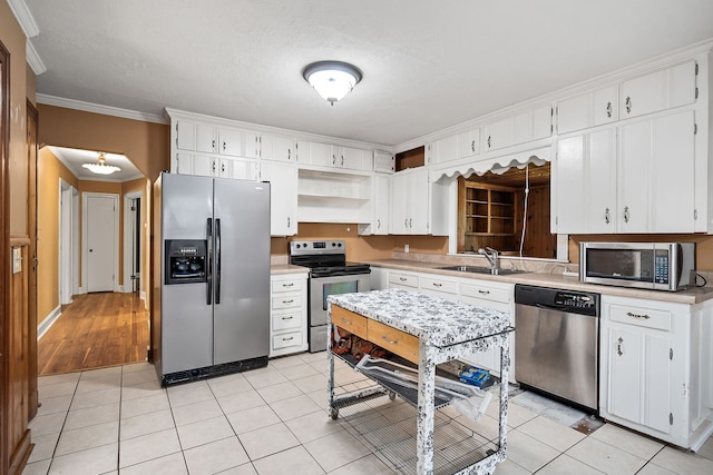 kitchen with crown molding, stainless steel appliances, sink, white cabinetry, and light hardwood / wood-style flooring