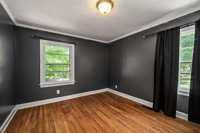 unfurnished room featuring hardwood / wood-style flooring, crown molding, and a textured ceiling