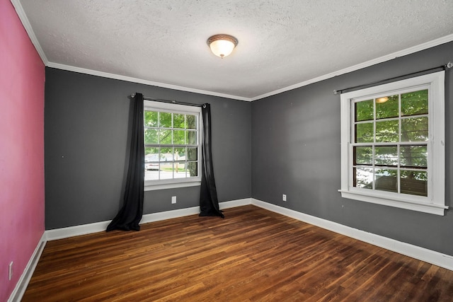 empty room with ornamental molding, dark hardwood / wood-style flooring, and a textured ceiling