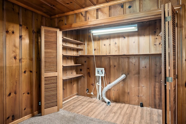 clothes washing area with wood walls, wood-type flooring, and washer hookup