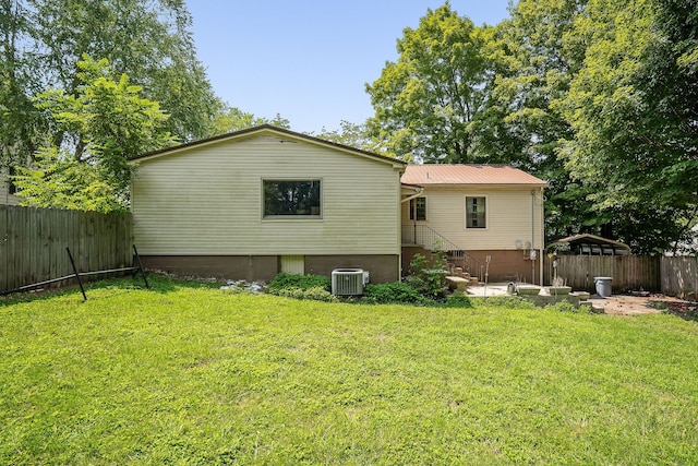 rear view of house with a lawn, a patio area, and central air condition unit