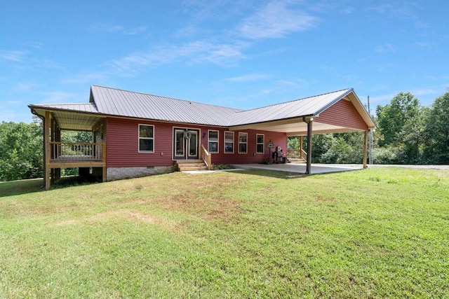 back of house with a patio and a lawn