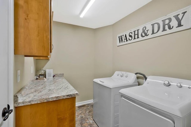 laundry area featuring cabinets and washer and clothes dryer