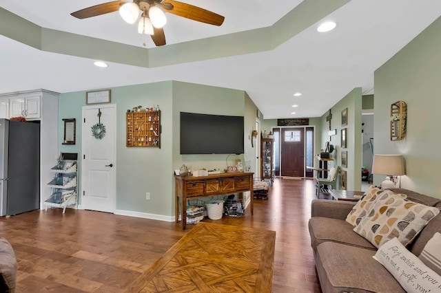 living room featuring ceiling fan and dark hardwood / wood-style flooring