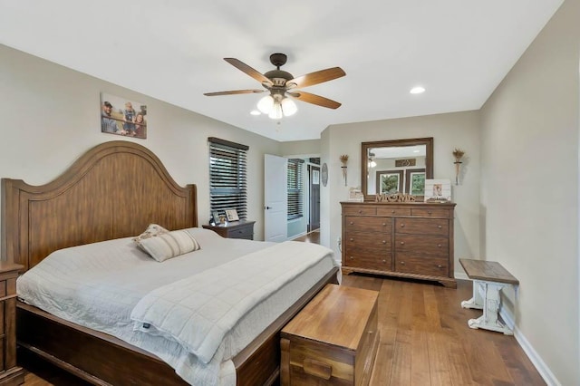 bedroom featuring hardwood / wood-style flooring, ceiling fan, and multiple windows