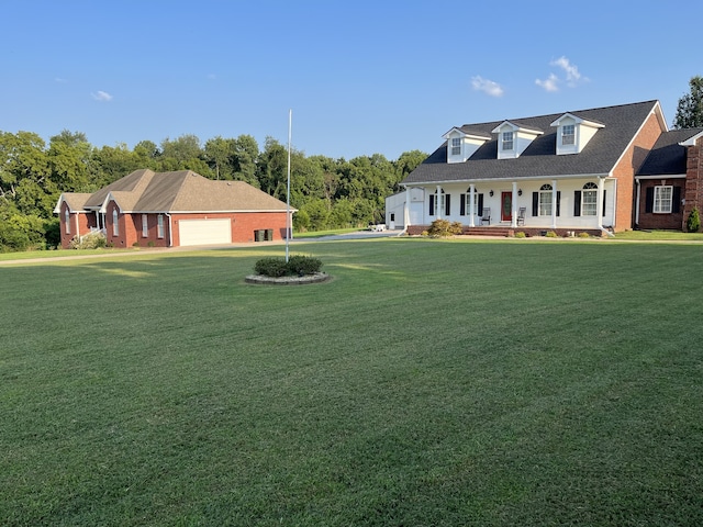 view of front of property with a garage, covered porch, and a front lawn