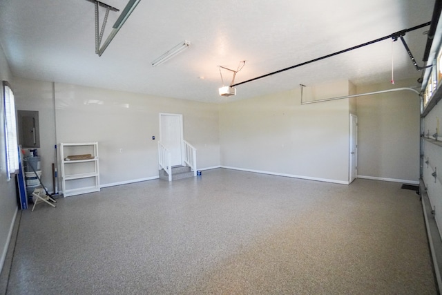 garage with a garage door opener and electric panel