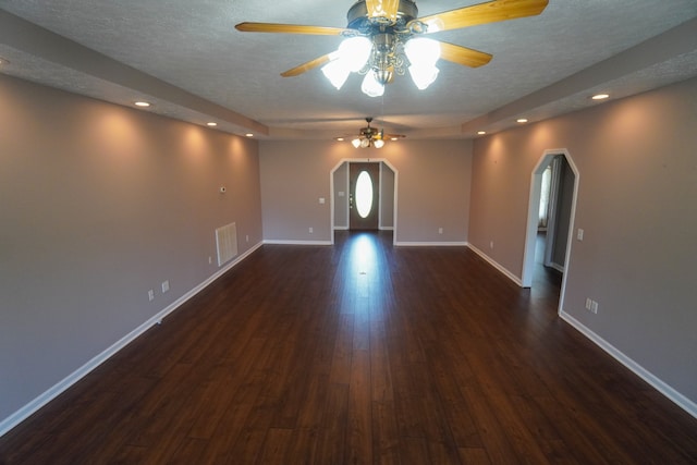 spare room featuring ceiling fan, dark wood-type flooring, and a textured ceiling