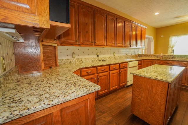 kitchen featuring white dishwasher, sink, light stone counters, and tasteful backsplash