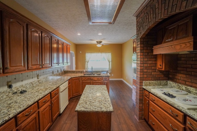 kitchen with white appliances, dark hardwood / wood-style flooring, light stone countertops, and sink