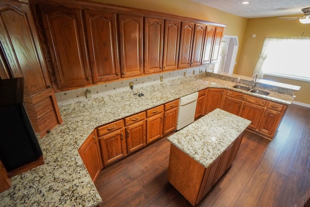 kitchen with dark hardwood / wood-style flooring, white dishwasher, kitchen peninsula, and sink