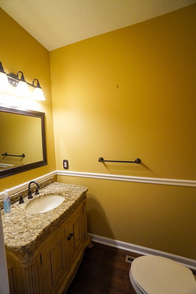 bathroom with vanity, wood-type flooring, and toilet