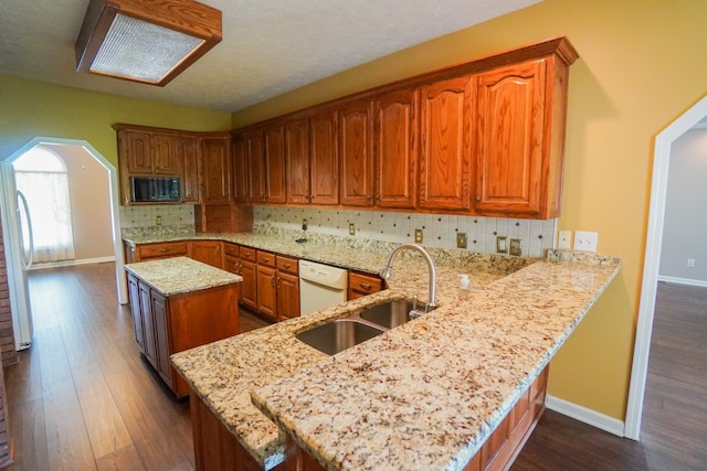 kitchen featuring sink, white appliances, backsplash, light stone countertops, and kitchen peninsula