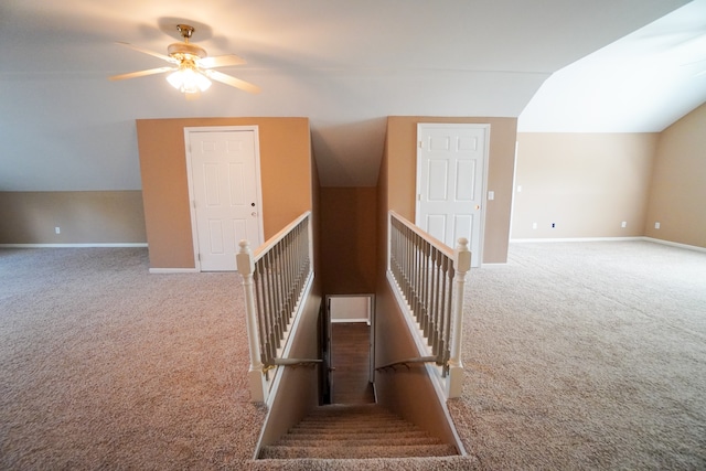 stairs with lofted ceiling, carpet floors, and ceiling fan