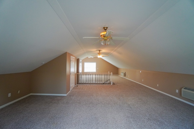 additional living space featuring vaulted ceiling, an AC wall unit, and carpet