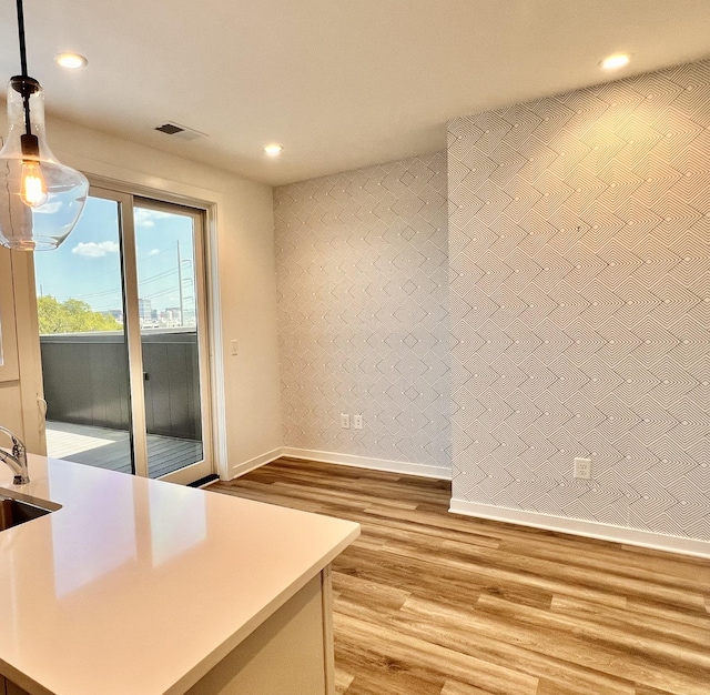 interior space featuring light wood finished floors, recessed lighting, visible vents, a sink, and baseboards