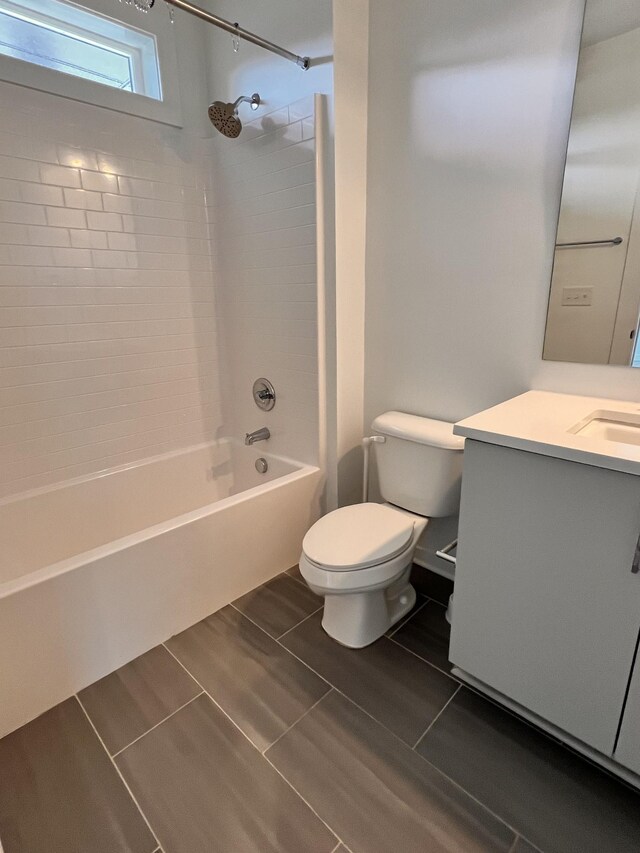 full bathroom featuring vanity, tiled shower / bath combo, toilet, and tile patterned flooring