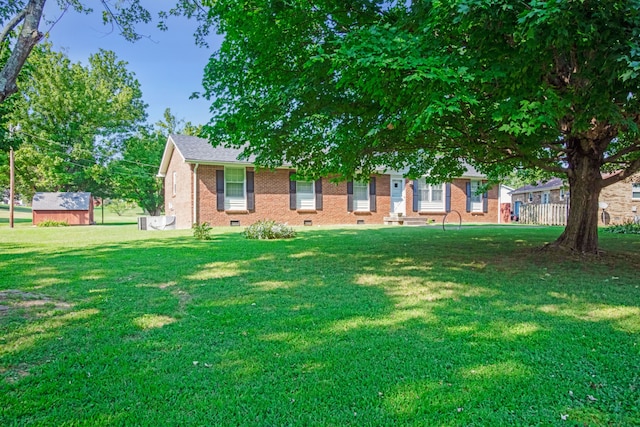 view of front of home featuring a front yard and an outbuilding