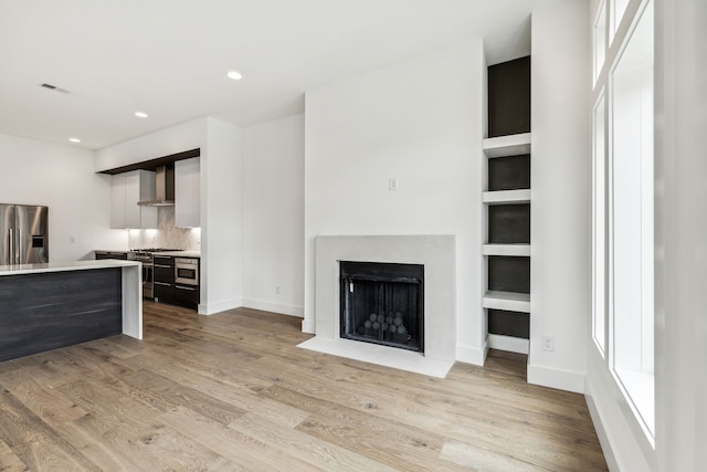 living room with light wood-type flooring and built in shelves