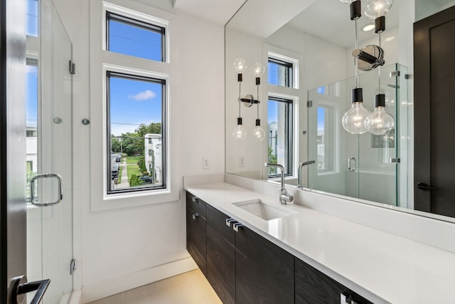 bathroom featuring a shower with door, vanity, and tile patterned flooring