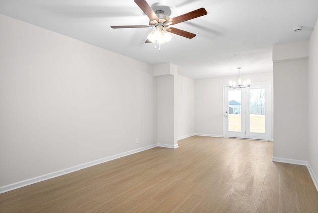 unfurnished room featuring ceiling fan with notable chandelier and light hardwood / wood-style floors