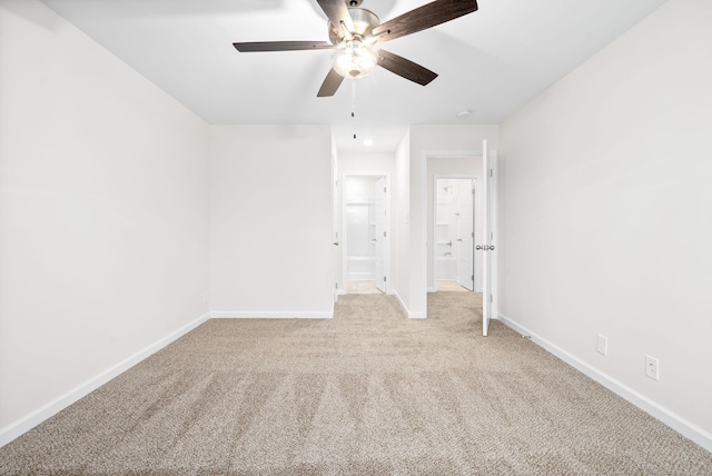 unfurnished bedroom featuring ceiling fan, light colored carpet, and ensuite bathroom