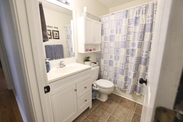 bathroom featuring tile patterned floors, vanity, and toilet