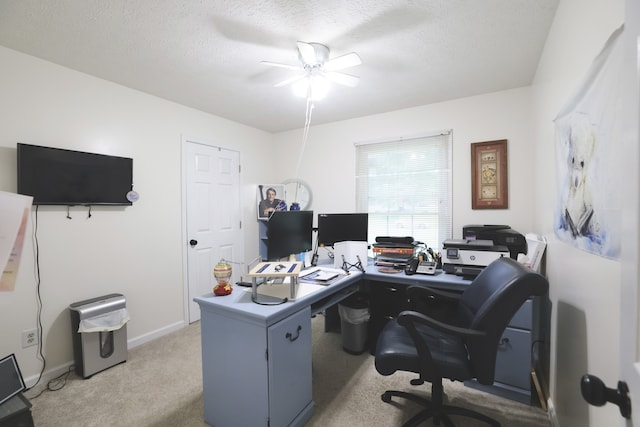 carpeted home office featuring a textured ceiling and ceiling fan