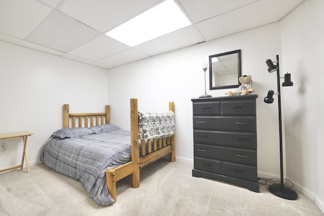 carpeted bedroom featuring a drop ceiling