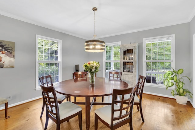 dining area with a notable chandelier, plenty of natural light, light hardwood / wood-style flooring, and ornamental molding