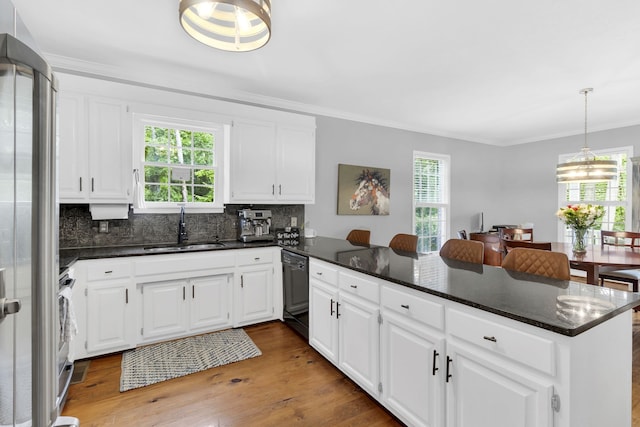 kitchen featuring sink, plenty of natural light, light wood-type flooring, and tasteful backsplash