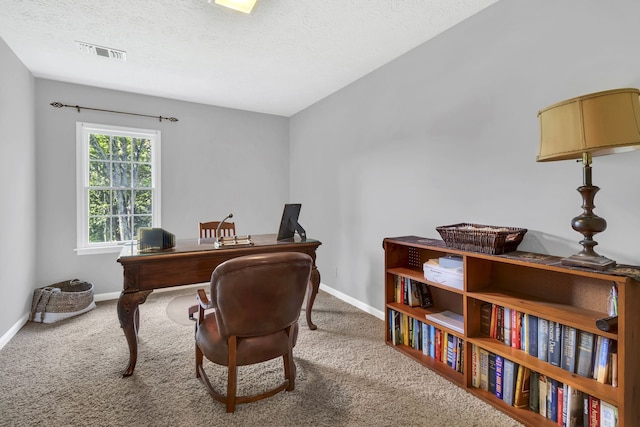 carpeted home office with a textured ceiling