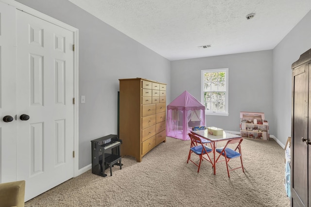 rec room featuring a textured ceiling and carpet floors