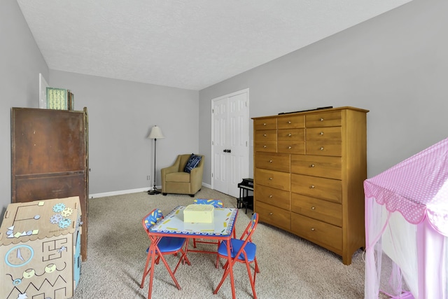 rec room with a textured ceiling and light carpet