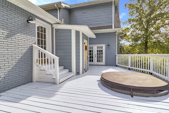 deck featuring a covered hot tub and french doors