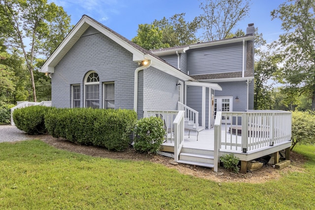 back of house with a wooden deck and a lawn