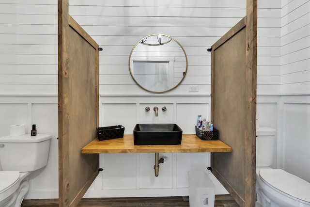 bathroom with toilet and hardwood / wood-style flooring