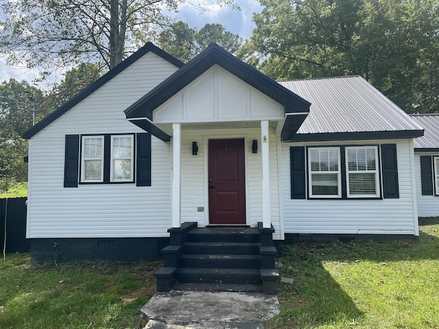 view of front of home featuring entry steps, metal roof, crawl space, and a front yard