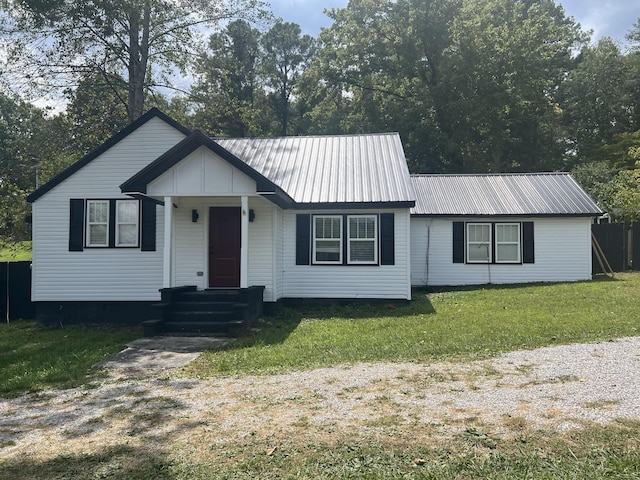 view of front of property with metal roof and a front lawn