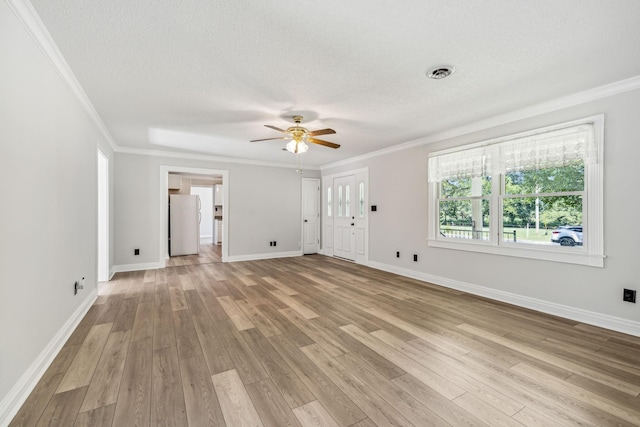 unfurnished room with visible vents, a textured ceiling, light wood-type flooring, and ornamental molding