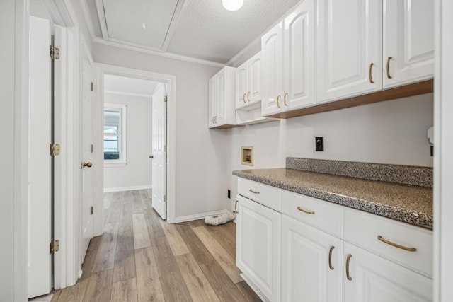 kitchen featuring dark countertops, light wood-style flooring, baseboards, and white cabinets