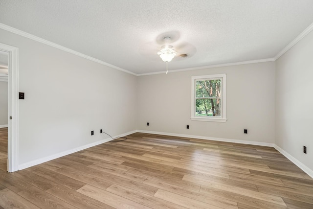 empty room with ornamental molding, a ceiling fan, a textured ceiling, light wood finished floors, and baseboards