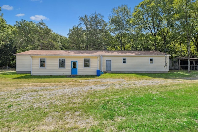 back of house with a lawn and fence