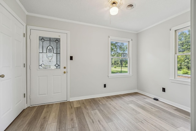 entrance foyer with light wood-type flooring, a healthy amount of sunlight, and crown molding