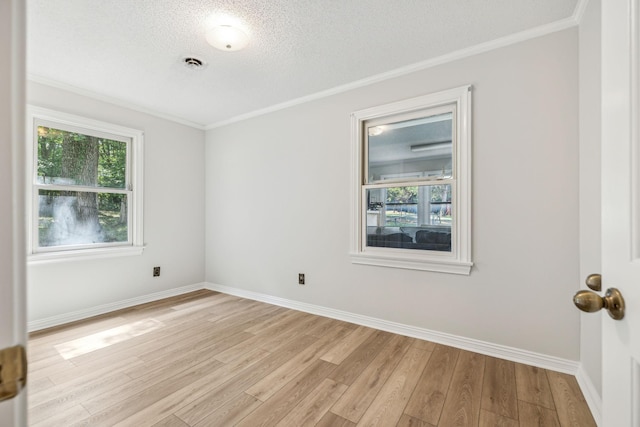 unfurnished room featuring light wood finished floors, visible vents, baseboards, and ornamental molding